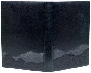 John Muir. Heaven on Earth. Illustrated by Charles D. Jones. Austin: Press Intermezzo, 1998. A French style binding with laced-on boards. The top edge is graphite with red silk hand sewn endbands. The book is covered in black goatskin with black emery paper and black morocco onlays, enclosed in a traditional chemise and slipcase. The shape and texture of the onlays suggest the mountain ranges dear to John Muir in his exploration of Yosemite. Sample binding submitted to the 2009 DeGolyer competition